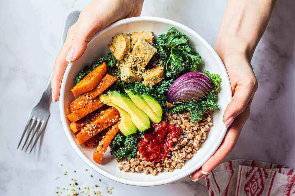 Bol bouddha de légumes cuits au four, avocat, tofu et sarrasin.