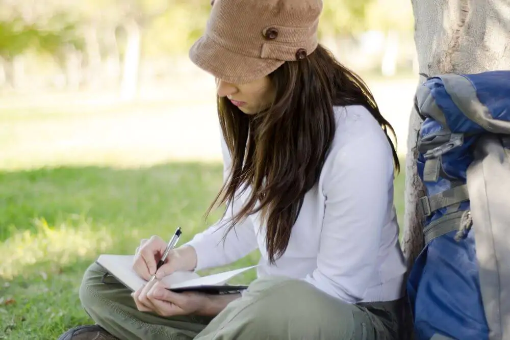 Donna che scrive sul suo diario di viaggio